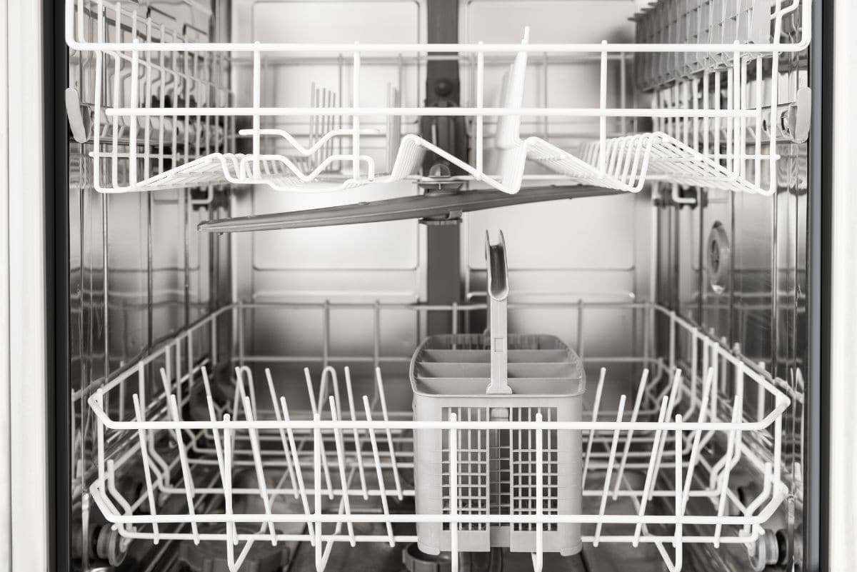 Внутренний вид пустой посудомоечной машины с белыми стеллажами